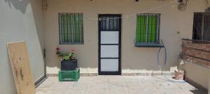 a room with a door and a window with a plant at La casita del parque in Mar del Plata