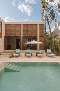 una casa con piscina con sedie e ombrellone di DECU DOWNTOWN a Mérida