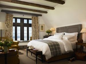 ein Schlafzimmer mit einem großen Bett mit weißer Bettwäsche und Kissen in der Unterkunft Trump International Golf Links & Hotel Doonbeg Ireland in Doonbeg