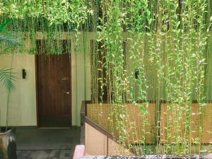 a building with a fence with plants and a door at ARTOTEL Haniman Ubud in Ubud