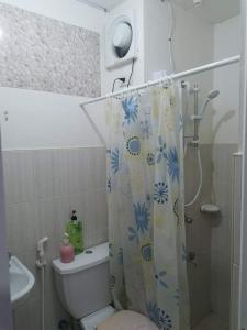 a bathroom with a shower curtain and a toilet at Chichi's Snug Pad near Enchanted Kingdom and Nuvali in Santa Rosa