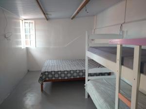 a bedroom with two bunk beds and a window at Peruíbe Centro - P&R in Peruíbe