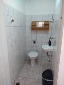 a small bathroom with a toilet and a sink at Peruíbe Centro - P&R in Peruíbe