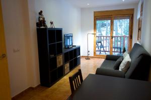 sala de estar con sofá y mesa con TV en Apartamento Supermolina Esquí, en La Molina