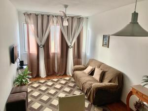 a living room with a couch and a window at Apto Praia Atalaia in Aracaju
