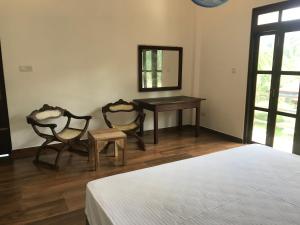 a bedroom with a bed and a table and two chairs at Om yoga Shala Beruwala - Yoga & Sound Healing in Beruwala +23 photos