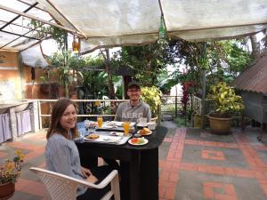 a man and a woman sitting at a table with food at Hostal Kurmi - Coroico in Coroico