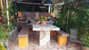 un tavolo e panche su un patio con piante di Villa Evelia a Aquitania