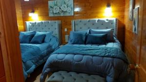 a bedroom with two beds with blue pillows at Villa Evelia in Aquitania