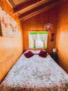 a bedroom with a bed in a room with a window at Cabañas Mi Escondite in Coihaique