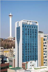wysoki budynek w mieście z wieżą w obiekcie Griffinbay Hotel w Pusanie