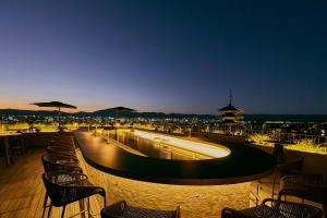 um bar no último piso com cadeiras e mesas e uma cidade em The Hotel Seiryu Kyoto Kiyomizu - a member of the Leading Hotels of the World- em Quioto