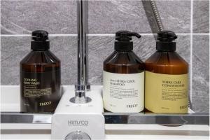 tres botellas de productos para el cabello sentadas en un estante en Griffinbay Hotel, en Busan