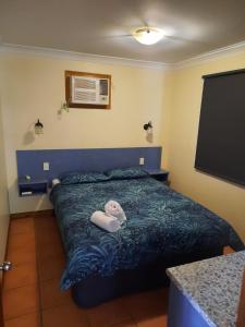 1 dormitorio con 1 cama con 2 toallas en Hay Point Hotel/Motel, en Hay Point
