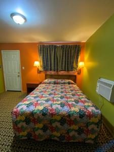 a bedroom with a bed with a colorful quilt at Lincoln Motel in Chandler