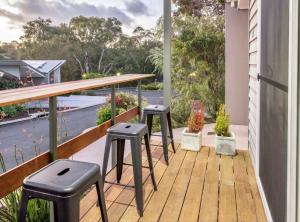 un porche con 2 taburetes y una mesa en el balcón en Villa Sedici @ Cape Villas Dunsborough en Dunsborough