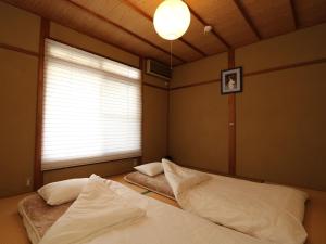 Rúm í herbergi á Guesthouse Kyoto-Yamashina