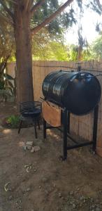a grill with a black cover next to a tree at Terraza del Molle in San Carlos
