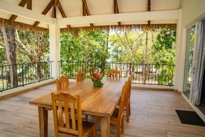 a wooden table and chairs on a screened in porch at Pavones Point in Pavones