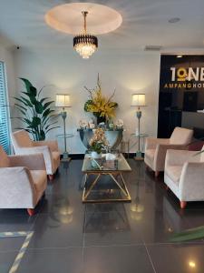 a lobby with couches and a table with flowers on it at ONE AMPANG HOTEL in Ampang