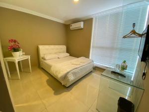 een slaapkamer met een bed, een tafel en een raam bij ONE AMPANG HOTEL in Ampang