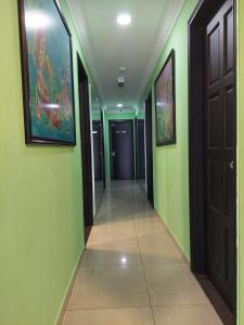 un pasillo con paredes verdes y un pasillo con puertas en ONE AMPANG HOTEL en Ampang
