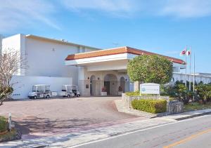 a building with two trucks parked in front of it at Royal View Hotel Churaumi in Motobu