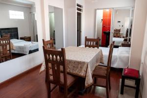 a dining room with a table and chairs and a bedroom at Residencial Velia & Victoria in Cochabamba