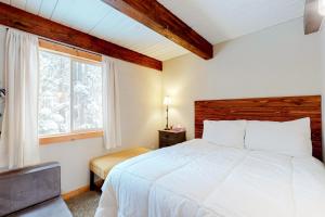 a bedroom with a white bed and a window at Cozy Cabin Retreat in South Lake Tahoe