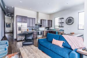 uma sala de estar com um sofá azul e uma cozinha em Adventure Awaits & Cana Lofts em Whitefish