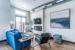 uma sala de estar com um sofá azul e uma mesa e cadeiras em Adventure Awaits & Cana Lofts em Whitefish