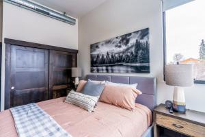 um quarto com uma cama e um quadro na parede em Adventure Awaits & Cana Lofts em Whitefish