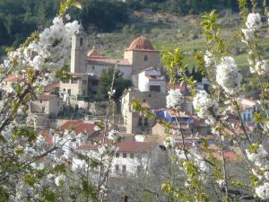 un pueblo con una iglesia en una colina con flores blancas en Casa Manolita en Puebla de Benifasar