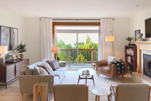 a living room with a couch and chairs and a fireplace at Three Capes Bungalow in Oceanside
