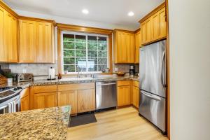 a kitchen with wooden cabinets and a stainless steel refrigerator at Three Capes Bungalow in Oceanside