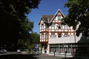 un grand bâtiment avec une maison sur le côté d'une rue dans l'établissement Hotel Schober am Kurpark, à Bad Salzschlirf