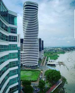 a tall building next to a body of water at Ecusuites Super Host Penthouse 10 River View Puerto Santana in Guayaquil
