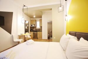 a bedroom with a large bed and a kitchen at GK Aria in Athens