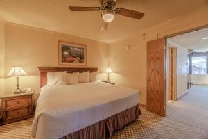 1 dormitorio con 1 cama grande y ventilador de techo en Grand Lodge Condo in the Heart of Mt CB condo en Crested Butte
