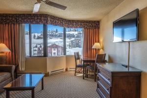 Habitación de hotel con escritorio y ventana grande. en Grand Lodge Condo in the Heart of Mt CB condo en Crested Butte