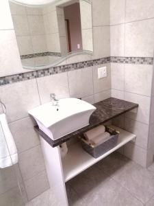 W białej łazience znajduje się umywalka i lustro. w obiekcie Theescombe Accomodation w mieście Port Elizabeth