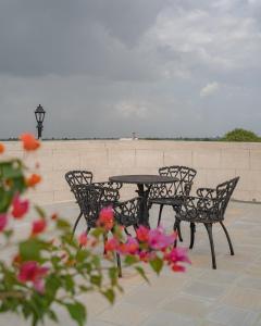 a table and chairs on a patio with flowers at Tree of Life Darbargadh Dared in Bhavnagar