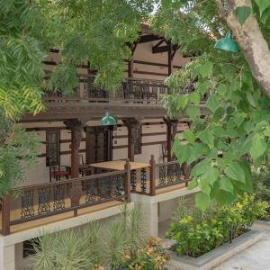 a building with a balcony and trees and plants at Tree of Life Darbargadh Dared in Bhavnagar