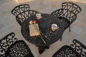 uma vista superior de uma mesa com duas chávenas e um livro em Tree of Life Darbargadh Dared em Bhavnagar