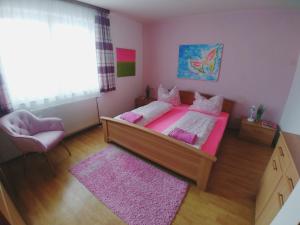 een slaapkamer met een bed, een stoel en een raam bij Appartement Mary in Schladming