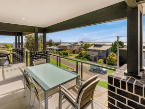 a patio with a table and chairs on a balcony at Castaway Views in San Remo