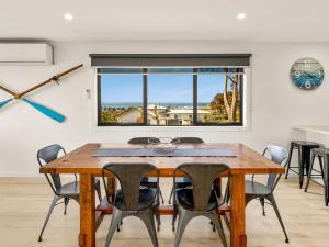 een eetkamer met een houten tafel en stoelen bij Castaway Views in San Remo