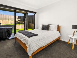 een slaapkamer met een bed en een groot raam bij Castaway Views in San Remo +10 foto's