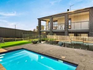 a swimming pool in front of a house at Castaway Views in San Remo