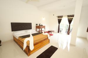 a bedroom with a large bed with white walls at The House Of Brothers in Arambol
